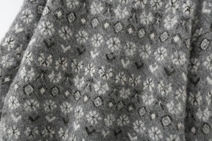 Detail of grey jacquard knit sweater featuring brushed mohair texture and retro floral patterns