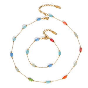 Minimalist gold stainless steel jewelry set with colorful square crystals on white base