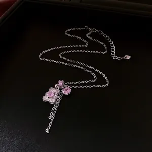 Silver bear necklace with pink zircon heart stones on elegant black leather tray
