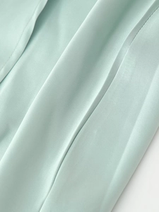 Dettaglio macro dell'elegante tessuto di raso verde menta con pieghe drappeggiate