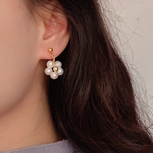 Elegant natural freshwater pearl flower earrings in gold finish worn by a female model