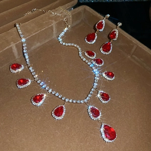 Detail of red teardrop gemstone necklace and earring set in a velvet jewelry box