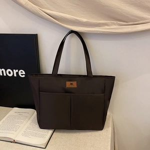 Minimalist dark brown nylon tote bag with front dual pockets and glossy casual finish