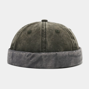 Detail of vintage washed fabric texture and rolled brim on the olive green docker cap