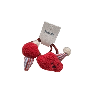 Plush red strawberry hair ties with plaid cap accents on a clean white background
