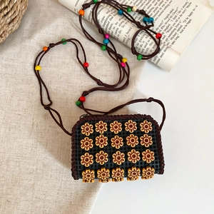 Close-up of handmade crochet crossbody bag with wooden flowers and colorful beads