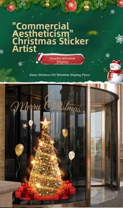 Detail of gold Merry Christmas window stickers with a tree and gift box on a glass door