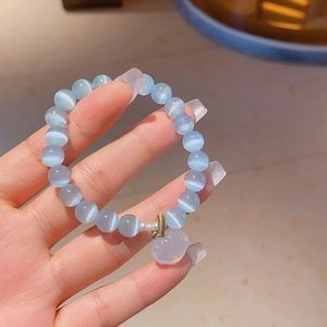 Detailed shot of blue cat eye stone bracelet featuring a translucent white rabbit charm