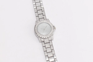 Detailed view of silver quartz watch with full diamond encrusted bezel and metal strap