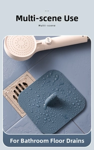 Blue square silicone drain cover with handle on bathroom tile with water droplets