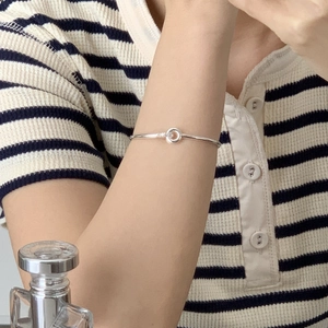 Detail of interlocking S925 silver bangles with pavé diamonds on a model's wrist