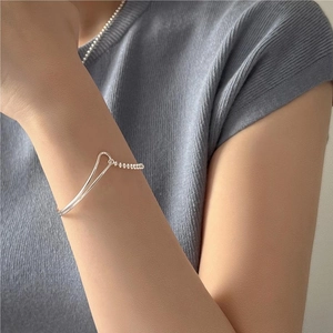 Close-up of S925 silver beaded bracelet with minimalist geometric curved line on wrist
