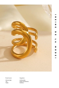 Vue macro d'une bague spirale dorée épaisse au design sculptural multicouche moderne