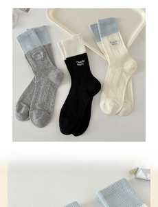 Detailed close-up of ribbed crew socks featuring embroidered Bebe Bonjour text