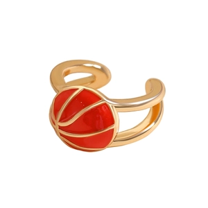 Λεπτομέρεια από χρυσό σκουλαρίκι ear cuff με σχέδιο μπάσκετ και κόκκινο σμάλτο