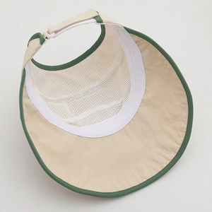 Detail view of breathable white mesh lining and adjustable strap on beige sun hat