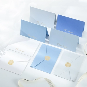 Detail of blue folding thank you cards with gold foil stamps and matching envelopes