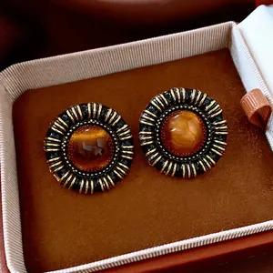 Vintage gold resin round stud earrings with amber cat-eye center and pleated metal texture