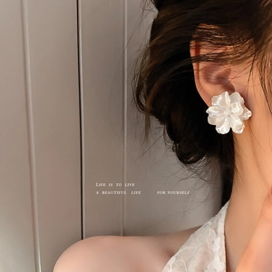 Elegante weiße Harz Kamelie Ohrstecker am Modell für einen minimalistischen Look