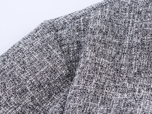 Close-up of grey tweed fabric texture and woven blend fibers on a suit set