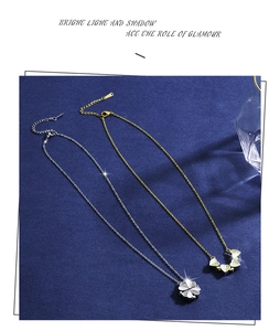 Detailed view of silver and gold heart pendants forming a clover on blue fabric