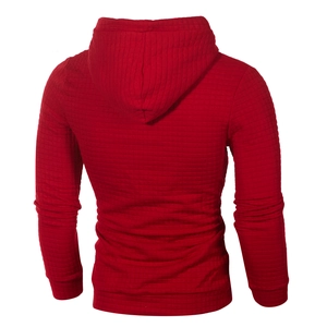 Detail view of red quilted hooded sweatshirt with textured fabric and ribbed cuffs