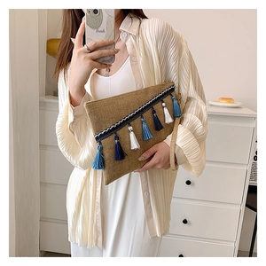 Detail of straw woven clutch with colorful fringes and woven ribbon trim texture