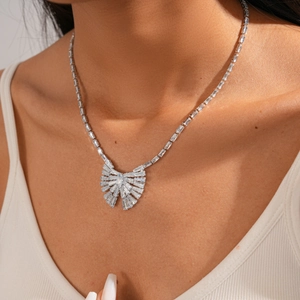 Dettaglio della collana con ciondolo a fiocco in zircone argento indossata da modella
