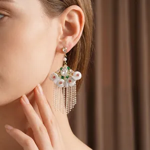 Vintage fan-shaped pearl earrings with rhinestones and long tassels on model