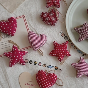 Red and white festive heart and star fabric ornaments with rustic linen texture
