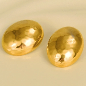 Detail view of gold teardrop earrings featuring a unique hammered metal texture and polished finish