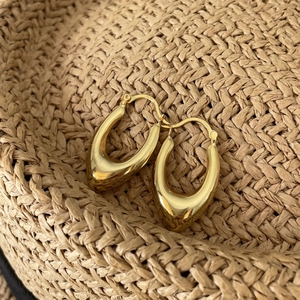 Macro shot of 925 sterling silver stamp on minimalist gold U-shaped hoop earrings