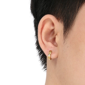 Detail of gold C-shaped titanium hoop earring with geometric patterns and zircon inlay