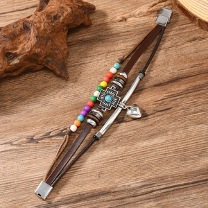 Detail of multi-layer leather bracelet with metal cross, heart charms and colorful beads