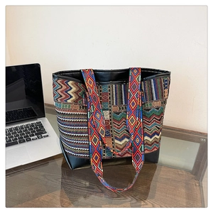 Detail of ethnic tote bag with geometric patterns, wide strap, and leather trim