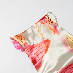 Détail macro du tissu satiné à fleurs avec fleur 3D et fine bretelle réglable