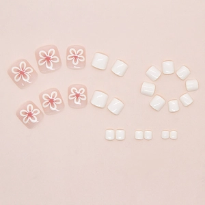 Detailed flat lay of cream floral press-on toenails in white and pink tones