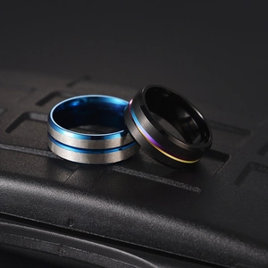 Macro shot of silver and black stainless steel men's rings with brushed finish texture