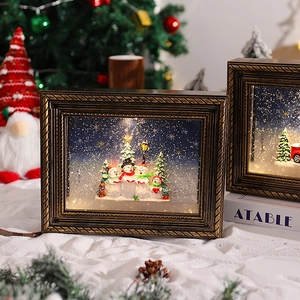 Detail of vintage bronze Christmas photo frame music box with glowing snowmen scene
