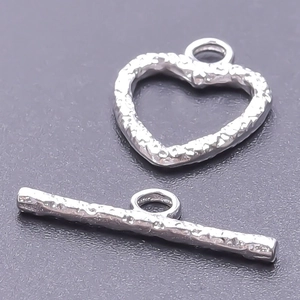 Macro detail of silver 304 stainless steel heart OT toggle clasp with hammer texture