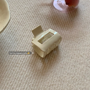 Macro detail of cream square acetate hair claw clip with stable metal spring mechanism