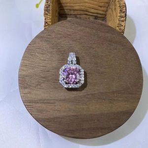 Detail of square halo pendant with pink round gemstone and pavé diamonds on silver base