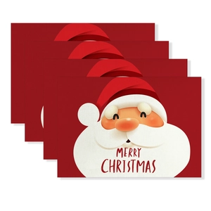 Close-up of four red Christmas placemats with Santa Claus print and textile texture