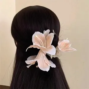 Close-up of a realistic 3D lily flower hair clip worn on long dark hair, elegant style