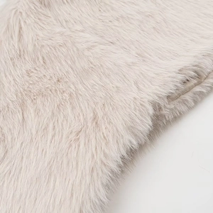 Close-up of soft beige faux fur texture showing high-density fluffy fibers in detail