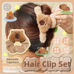 Detail of plush capybara hair scrunchie and claw clip set with embroidery