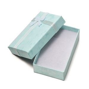 Detail of light blue rectangular jewelry gift box with a white ribbon bow and foam insert