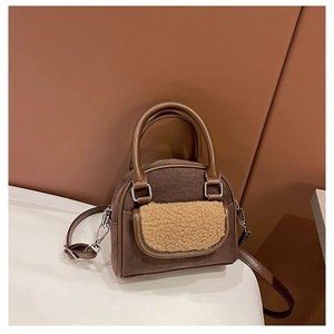 Detailed close-up of brown suede shoulder bag featuring beige plush shearling trim detail