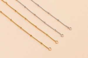 Detail von Satellite-Ketten in Gold und Silber mit Perlengliedern und Ringenden