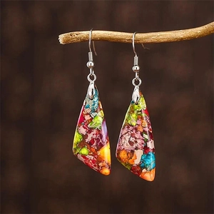 Bohemian teardrop earrings with colorful imperial stones hanging on a wooden branch